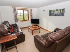 A living room with a sofa, coffee table and television at Bwthyn-y-Rhiw Penybanc near Llandeilo
