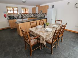 A kitchen with a dining table and chairs at Bwthyn-y-Rhiw in Penybanc near Llandeilo