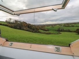A view of greenery and hills through a window at Bwthyn-y-Rhiw near Penybanc near Llandeilo