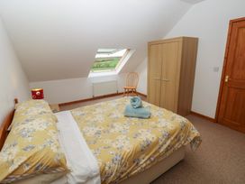 A bedroom with a bed and a wardrobe at Bwthyn-y-Rhiw in Penybanc near Llandeilo