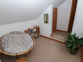 A snug with a papasan chair and a bookshelf at Bwthyn-y-Rhiw in Penybanc near Llandeilo