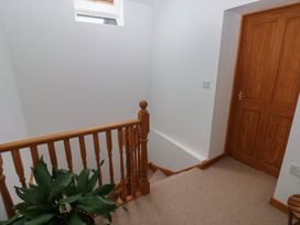 A staircase with wooden rail and door at Bwthyn-y-Rhiw in Penybanc near Llandeilo