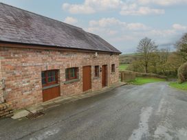 A brick building with wooden doors and windows near a road at Bwthyn-y-Rhiw Penybanc near Llandeilo