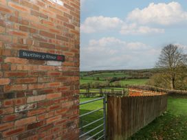 A brick wall with a sign and a view of the landscape at Bwthyn-y-Rhiw Penybanc near Llandeilo