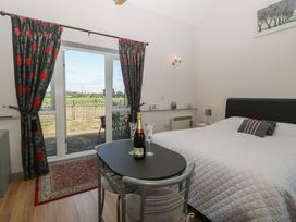 A bedroom with a bed and table at Snowy Owl Barn in Shipdham
