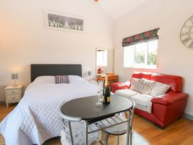 A bedroom with a bed and seating area at Snowy Owl Barn in Shipdham