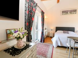A bedroom with a bed and decorative furnishings at Snowy Owl Barn Shipdham