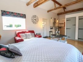 A studio with a bed and kitchenette at Snowy Owl Barn in Shipdham