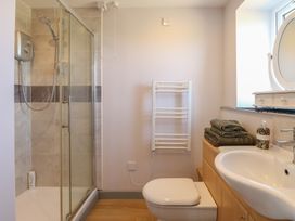 A bathroom with a shower, toilet, sink, and towel rail at Snowy Owl Barn in Shipdham