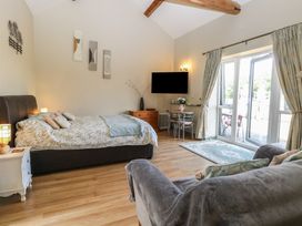 A bedroom featuring a bed with cushions and a table with chairs at Tawny Owl Barn Shipdham near Dereham