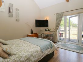 A bedroom with a bed and table at Tawny Owl Barn Shipdham near Dereham