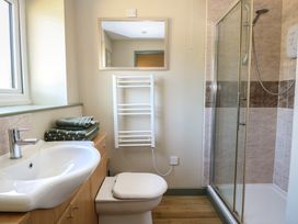 A bathroom with a sink, toilet, towel rack, and shower at Tawny Owl Barn Shipdham near Dereham