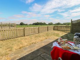 An outdoor space with a table set for tea at Tawny Owl Barn Shipdham near Dereham