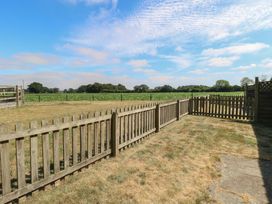 An outdoor area with a wooden fence and a view of a farm field at Tawny Owl Barn Shipdham near Dereham