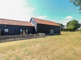 A barn with a fence and grass at Tawny Owl Barn Shipdham near Dereham