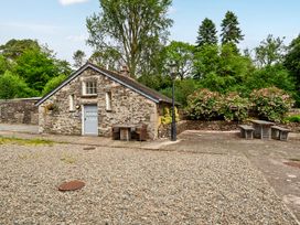 A stone building with benches and a flower bed at Can Brow at the Graythwaite Estate near Hawkshead
