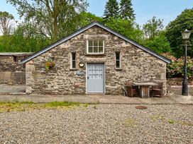 A stone building with a table and chairs at Can Brow at the Graythwaite Estate near Hawkshead