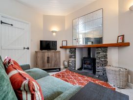 A living room with a sofa and television at Can Brow at the Graythwaite Estate near Hawkshead