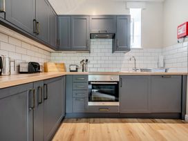 A kitchen with cabinets, an oven, and a sink at Can Brow at the Graythwaite Estate near Hawkshead