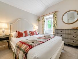 A bedroom with a bed and a dressing table at Can Brow at the Graythwaite Estate near Hawkshead