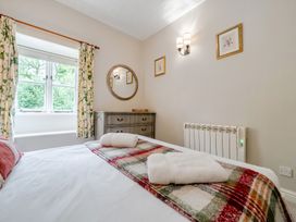 A bedroom with a bed and dresser at Can Brow at the Graythwaite Estate near Hawkshead