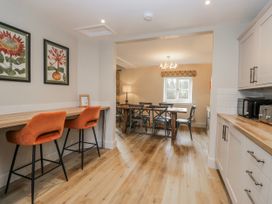 A kitchen with bar stools and a table at Jubilee in Graythwaite near Hawkshead