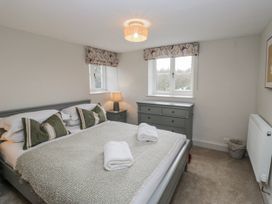 A bedroom with a bed and dresser at Jubilee in Graythwaite near Hawkshead