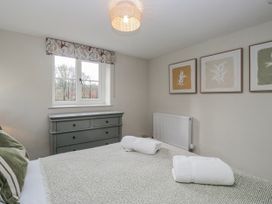 A bedroom with a bed and dresser at Jubilee in Graythwaite near Hawkshead