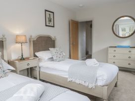 A bedroom with two beds and a dresser at Jubilee in Graythwaite near Hawkshead
