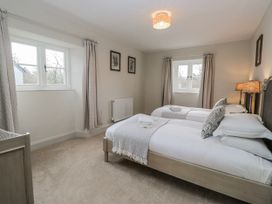 A bedroom with two single beds and a window at Jubilee in Graythwaite near Hawkshead