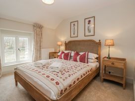 A bedroom with a bed and bedside table at Jubilee in Graythwaite near Hawkshead