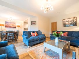 A living room with sofas, a coffee table, and a dining area at Jubilee at the Graythwaite Estate Graythwaite near Hawkshead