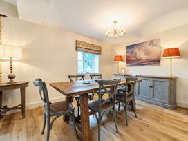 A dining room with a wooden table and six chairs at Jubilee at the Graythwaite Estate Graythwaite near Hawkshead
