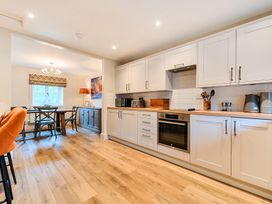 A kitchen with cabinets and a table at Jubilee at the Graythwaite Estate Graythwaite near Hawkshead