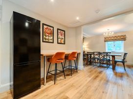 A kitchen with a refrigerator and bar stools at Jubilee at the Graythwaite Estate in Graythwaite near Hawkshead