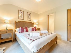 A bedroom with a bed and nightstand at Jubilee at the Graythwaite Estate near Hawkshead