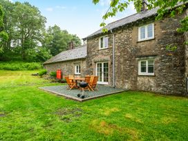 An outdoor dining setup with chairs and a grill at Jubilee at the Graythwaite Estate near Hawkshead