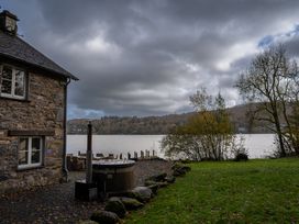 An outdoor area with a hot tub near a lake at Hammerhole in Graythwaite near Hawkshead