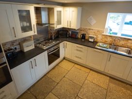 A kitchen with cabinets, stove, sink and appliances at Hammerhole in Graythwaite near Hawkshead