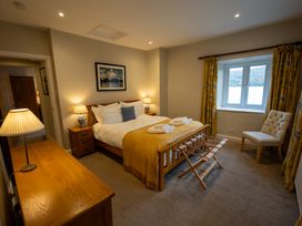 A bedroom with a bed and a chair at Hammerhole in Graythwaite near Hawkshead