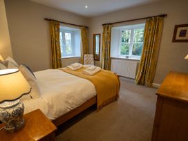 A bedroom with a bed and two windows at Hammerhole in Graythwaite near Hawkshead