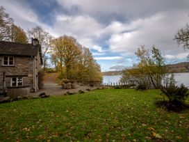 A house by a lake with trees and grass at Hammerhole in Graythwaite near Hawkshead