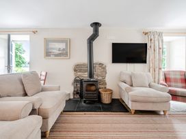 A living room with a fireplace and seating area at Hammerhole at the Graythwaite Estate near Hawkshead