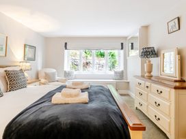 A bedroom with a bed, dresser, and armchair at Hammerhole at the Graythwaite Estate near Hawkshead