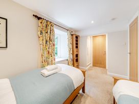 A bedroom with two beds and a window at Hammerhole at the Graythwaite Estate near Hawkshead