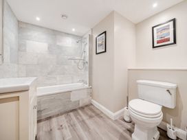 A bathroom with a bathtub, shower, sink, and toilet at Hammerhole at the Graythwaite Estate near Hawkshead