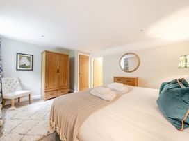 A bedroom with a bed and wardrobe at Hammerhole at the Graythwaite Estate near Hawkshead