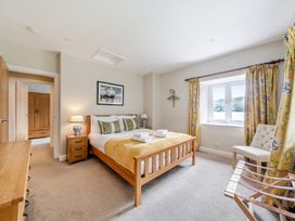 A bedroom with a bed and nightstand at Hammerhole at the Graythwaite Estate near Hawkshead