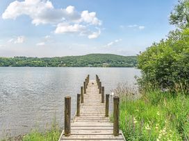 A dock extending over water with trees in the background at Hammerhole at the Graythwaite Estate Graythwaite Estate near Hawkshead