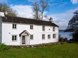 A house near a lake with trees and garden at Hullet Hall Graythwaite near Hawkshead